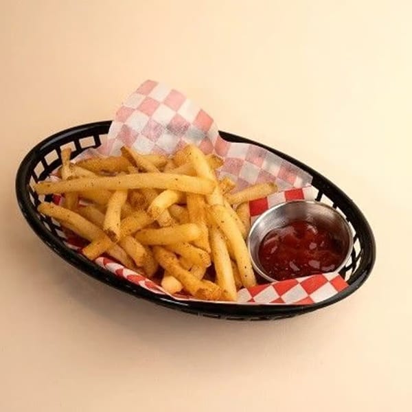 A black basket of golden french fries with a side of ketchup on a checkered paper liner.